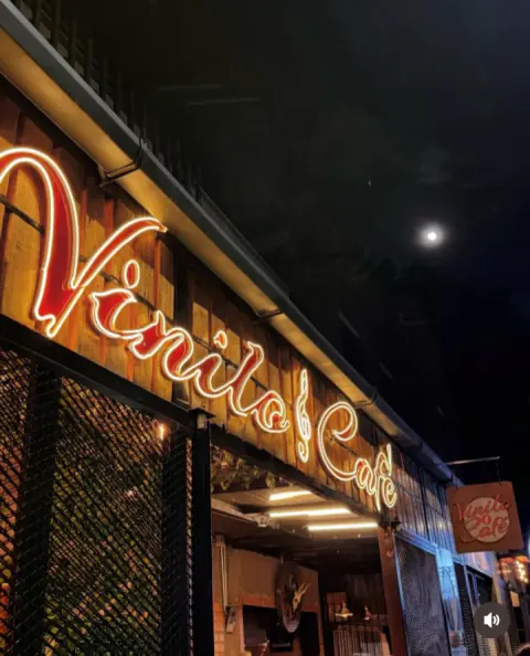 Aviso de Vinilo & Café en neón rojo, de noche