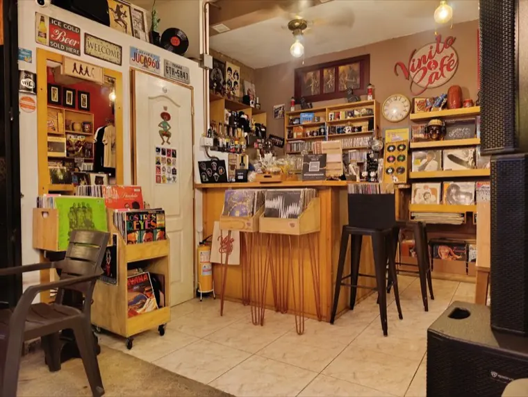 Barra de café rodeada de estantes con discos y recuerdos musicales