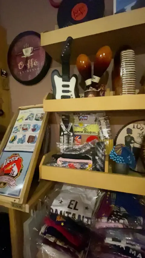 Estante con figuras, pequeñas guitarras y objetos musicales