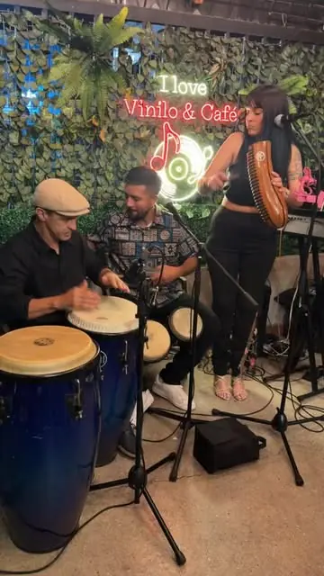 Músicos con congas y una cantante en una noche de música en vivo