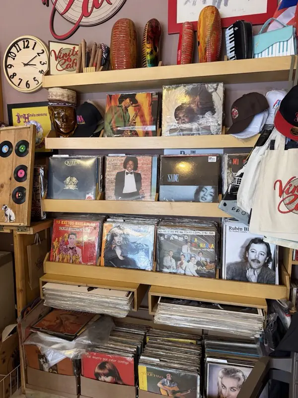 Estante con discos de vinilo, maracas y afiches
